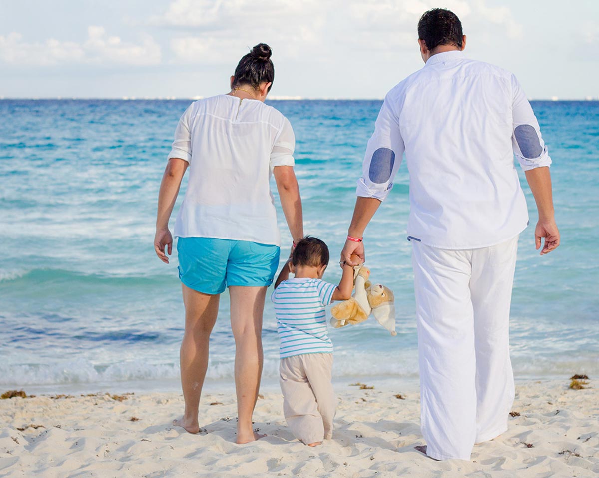 Mother, father, and child walking on beach
